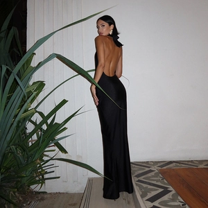 Detail of elegant black backless maxi dress with halter neck and silky satin texture