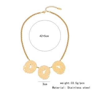 Detail of gold stainless steel necklace with hammered irregular round pendants on white background