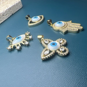 Golden Evil Eye pendants with shell inlay featuring Hamsa hand and clover designs