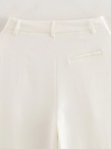 Close-up of white high-waisted trousers with belt loops and faux pocket detail