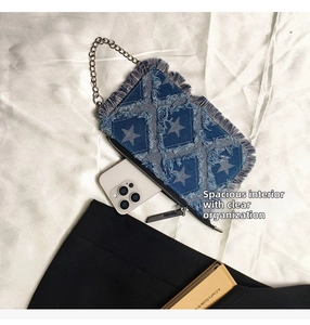 Detail view of denim star pattern bag with fringe edges and metal chain strap