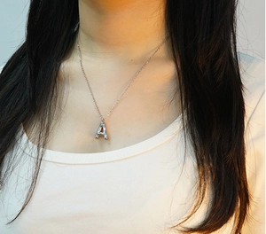 Macro shot of silver chubby bubble letter A pendant on a stainless steel necklace