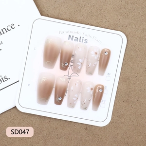 Brown gradient press-on nails with white flower patterns and sparkling small rhinestones
