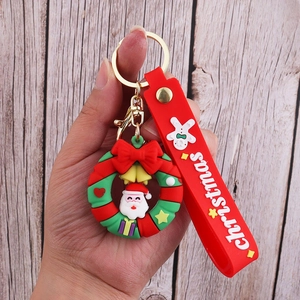 Detail of Christmas Santa PVC keychain with red strap on wooden background