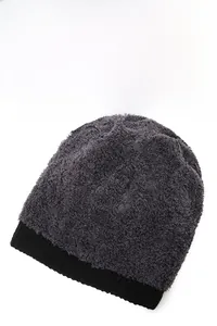 Detailed view of winter knit beanie showing thick plush faux fur and ribbed cuff texture