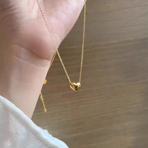 Detail of 18K gold heart necklace featuring a high-polished minimalist heart-shaped pendant