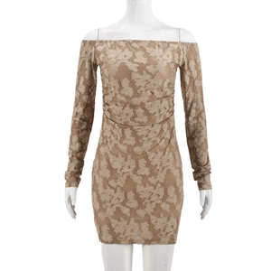 Détail du tissu jacquard en dentelle marron avec motifs floraux 3D sur une robe moulante