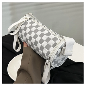 Macro shot of checkered cylinder shoulder bag showing pleated texture and silver hardware