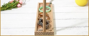 Detail of wooden jewelry stand featuring a rectangular base and a vertical T-bar display