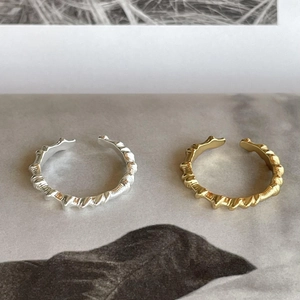 Macro detail of 925 sterling silver rings with twisted texture in silver and gold finish