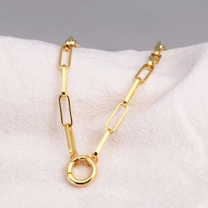 Macro shot of gold-plated paperclip chain link with a circular spring ring clasp detail