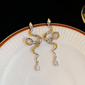Silver snake-shaped drop earrings with yellow enamel patterns and pear-cut crystal charms