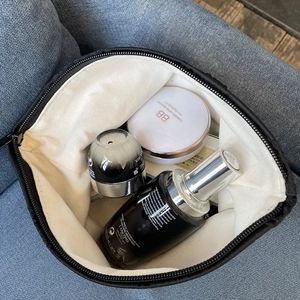 Top-down view of black jacquard rose vanity bag on a sofa showing large capacity storage