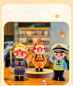 Detailed close-up of cute cartoon firefighter and police officer PVC keychains with gold clips