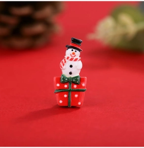 Macro shot of a Christmas snowman figurine on a red gift box made of resin material