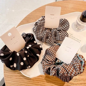 Set of three Korean scrunchies with polka dot and houndstooth patterns on a tray