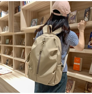 Close-up of khaki nylon backpack with unique braided rope zipper pulls in a library