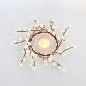 Détail de la couronne de baies blanc crème avec bougeoir en verre et chauffe-plat