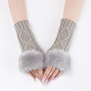 Detail of light gray cable knit fingerless gloves with soft faux fur trim around the wrists