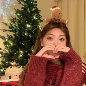 Cute gingerbread man plush headband with festive Christmas hat shown on a model