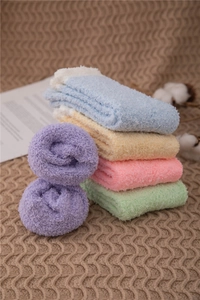 Close-up of assorted pastel thick coral fleece warm socks in a cozy lifestyle setting