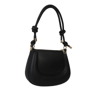 Minimalist black matte saddle shoulder bag with decorative knots and gold hardware detail