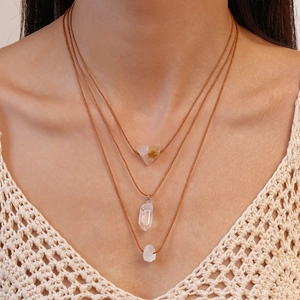 Bohemian three-layer necklace featuring raw crystal pendants on brown woven ropes