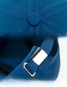 Detail of navy cotton baseball cap showing top button stitching and adjustable metal buckle