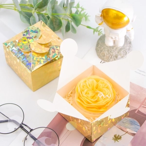 Detailed view of yellow rose candle in laser gold gift box packaging with elegant decor