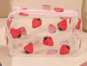 Detail of transparent PVC strawberry print makeup bag with pink zipper closure