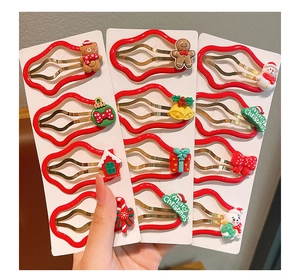 Detailed view of red Christmas hair clips featuring bear, snowman and bell characters