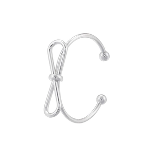Close-up of a silver bow-knot ear cuff with metal bead detail on white background