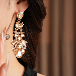 Gros plan détaillé des boucles d'oreilles vintage goutte d'eau dorées avec des cristaux