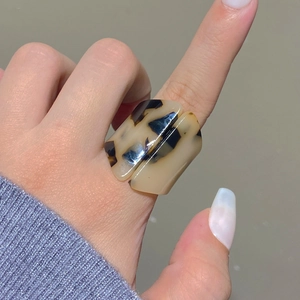 Close-up of a bold rectangular acrylic ring with leopard tortoise shell patterns