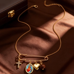 Detail of vintage gold necklace with cross, Mary portrait, and heart charms on silk