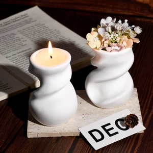 Détail de l'ensemble bougeoir spirale blanc et mini vase dans un décor chaleureux