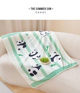 Detail einer weichen grün-weiß gestreiften Pandadecke auf einem Sofa zu Hause
