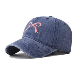 Cappellino in cotone lavato blu navy con ricamo fiocco rosa in vista laterale a 45 gradi