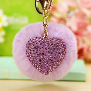 Close-up of heart charm keychain with purple rhinestones and a soft purple faux fur pompom