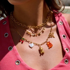 Close-up of layered 18K gold-plated stainless steel necklaces with cute charms and beads