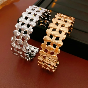 Detail of chunky gold and silver oval hollowed bangles on luxury leather backdrop