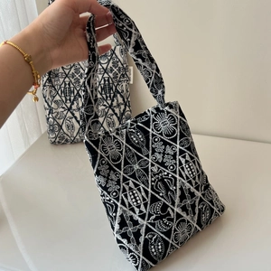 Close-up of geometric floral embroidery on vintage canvas tote bags with bird patterns