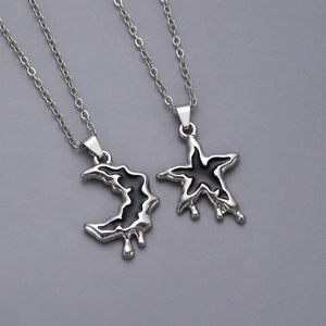 Detail of silver liquid lava moon and star pendants with black enamel finish