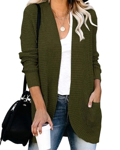 Dettaglio della trama del cardigan in maglia verde scuro con ampie tasche laterali