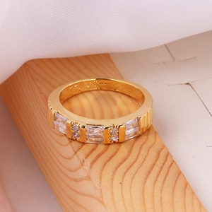 Close-up of gold ring with alternating rectangular and round clear cubic zirconia stones