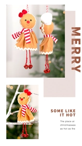Close-up of a gingerbread man ornament with red scarf and bell on a Christmas tree