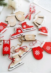 Flat lay of Nordic wooden Christmas tree ornaments featuring mini red skates and sleds
