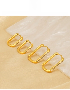 Detailed view of U-shaped gold titanium steel earrings with sparkling white zircons