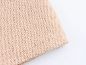 Vue macro détaillée du tissu tissé beige respirant avec un ourlet cousu de haute qualité