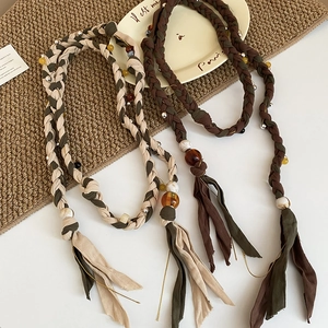 Macro view of bohemian woven cotton belt with resin crystal beads and fabric tassels